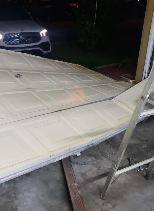 Garage door off track Garage door is off track completely on the floor